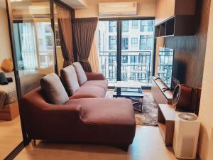 a living room with a couch and a large window at La casita hua hin in Hua Hin