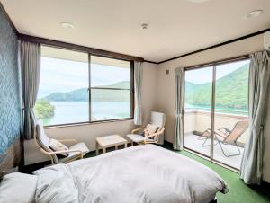 una camera da letto con un letto e sedie e una grande finestra di H,U,B Unzen - Vacation STAY 01672v a Unzen