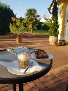 a table with a drink and a plate of food at Éden Villa - Family Apartmanok in Balatonfüred +90 photos