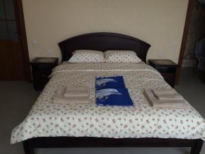 a bed with a blue and white comforter and pillows at Admiral 2 in Koblevo