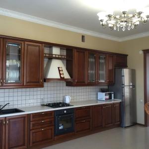 a kitchen with wooden cabinets and a stainless steel refrigerator at Admiral 2 in Koblevo