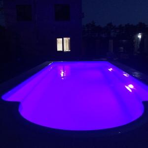 a swimming pool with purple lights in the dark at Admiral 2 in Koblevo