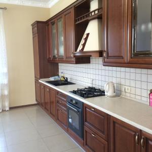 a kitchen with wooden cabinets and a stove top oven at Admiral 2 in Koblevo