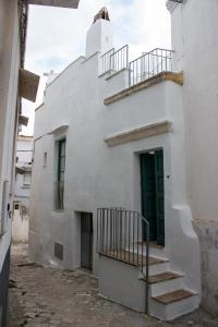 - un bâtiment blanc avec des escaliers sur son côté dans l'établissement Casetta di paese, à Matino