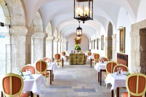 um restaurante com mesas e cadeiras num corredor com tectos em Pousada Castelo de Palmela em Palmela