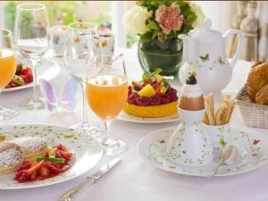 a table with plates of food and glasses of orange juice at Hotel Rose Palace in Surat