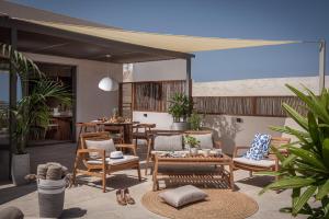 a patio with chairs and a table and a tableablish at Theatro Living in Elegance - Luxury Apartments in Hersonissos in Hersonissos +37 photos