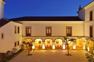 un gran edificio con patio por la noche en Pousada Castelo de Palmela, en Palmela