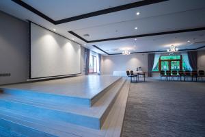 a large room with a stage and a large screen at Hotel Gorczowski Katowice Chorzów in Chorzów