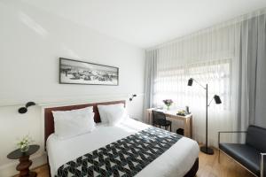 a bedroom with a large bed and a large window at Lily & Bloom Boutique Hotel in Tel Aviv