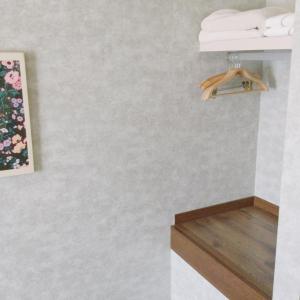 a bathroom with white walls and a shelf with towels at Apartment Hotel Mimoza - Vacation STAY 90043v in Sumoto