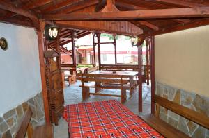a screened in porch with a table and benches at Armira Family Hotel in Ivaylovgrad