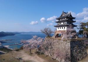 a castle on top of a stone wall next to the water at Apartment Hotel Mimoza - Vacation STAY 92095v in Sumoto