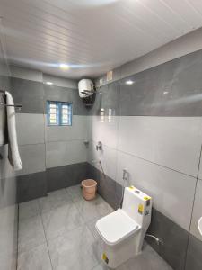 a bathroom with a white toilet and a shower at Venattu Homestay in Thekkady