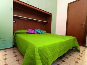 - un lit vert avec 2 oreillers dans l'établissement Residence Carina, à Bibione