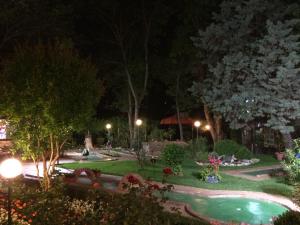 a garden at night with a swimming pool at Oleander House and Tennis Club in Sunny Beach