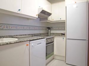 una cucina bianca con lavandino e frigorifero di ApartUP L'Umbracle a Valencia