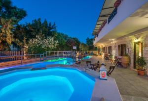 a swimming pool in front of a building at Dante's Maisonettes in Amoudi