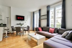 een woonkamer met een bank en een tafel bij Appartement Quartier Champs-Élysées 4 Free Netflix in Parijs