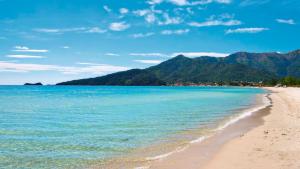 a beach with the ocean and mountains in the background at Johny's Studios in Prinos