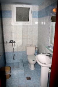 a bathroom with a toilet and a sink at Johny's Studios in Prinos