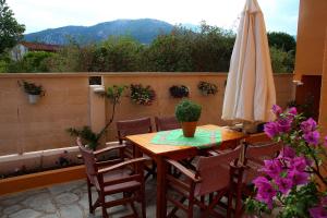 a table and chairs with a umbrella on a patio at Johny's Studios in Prinos +1 photo
