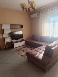 Una sala de estar con un sofá y un televisor de pantalla plana. en Keti APT, en Kashari