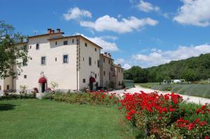 budynek z czerwonymi kwiatami przed drogą w obiekcie Relais Santa Margherita w Arezzo