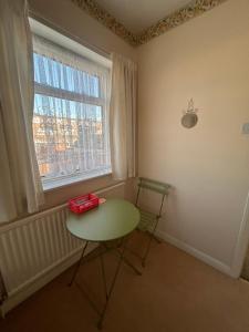 ein Tisch und ein Stuhl in einem Zimmer mit Fenster in der Unterkunft Gravesend in Gravesend