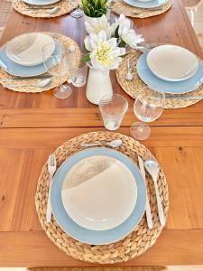 a wooden table with blue and white plates and silverware at Les Flors de Cunit Villa Liria in Cunit