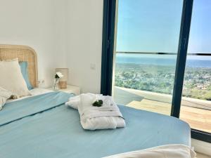 a bedroom with a bed with towels on it at Les Flors de Cunit Villa Liria in Cunit