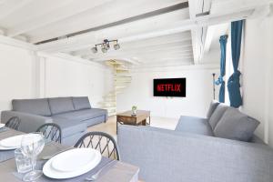 a living room with two couches and a table with chairs at Appartement Quartier Place de la Bastille Free Netflix in Paris