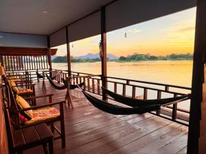 a room with two hammocks and a view of a river at Namknong view in Don Det