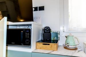 a kitchen counter with a microwave and a tea kettle at Bolhome Botanique-NR the Center in Bologna +14 photos