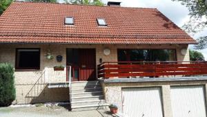 a small brick house with a red roof at Ferienwohnungen Haus am Karpfenteich in Hahnenklee-Bockswiese