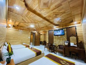a hotel room with two beds and a piano at Thanh Thuy Hotel in Da Lat