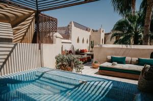 een zwembad op een terras met een bank bij Riad Vert in Marrakesh