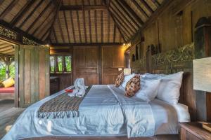 ウブドにあるUbud Garden Villaの木製の壁のベッドルーム1室(大型ベッド1台付)