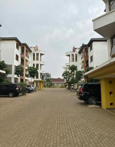 a parking lot with cars parked in front of buildings at Ssumo Comfy Stays in Kisumu