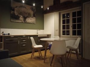 a kitchen with a table and some white chairs at Face à face époustouflant avec la cathédrale ! in Le Puy en Velay