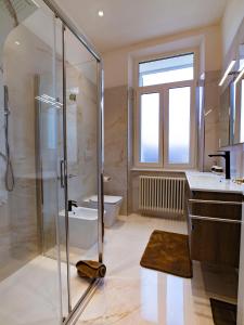 une salle de bain avec douche, lavabo et toilettes dans l'établissement La Finestra sul Corso, Gorizia, à Gorizia