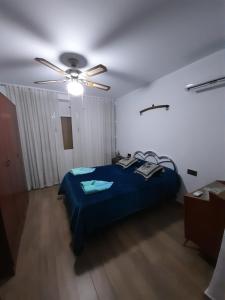 una camera con letto blu e ventilatore a soffitto di Alojamiento rural La Hontana a Castillo de Locubín