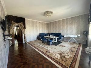 un soggiorno con un divano blu e un tavolo di Cozy apartment a Samarkand