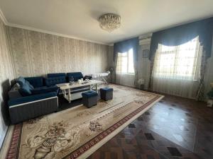 un soggiorno con un divano blu e un tavolo di Cozy apartment a Samarkand