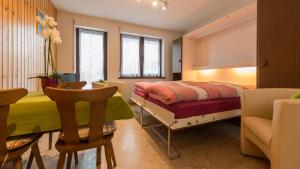 a bedroom with a bed and a table and chairs at Apartments Orphelja in Saas-Grund