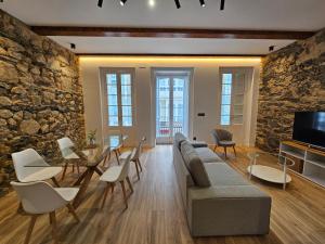 a living room with a couch and a table and chairs at Apartamento Plaza de Armas in Ferrol