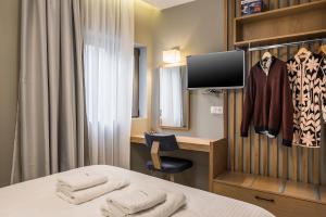 a room with a bed and a desk and a tv at Mirma City apartment2 Old Town in Chania