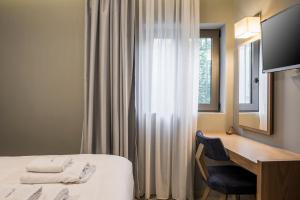 a hotel room with a bed and a desk and a window at Mirma City apartment2 Old Town in Chania +16 photos