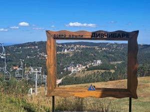 a sign on top of a hill with a view at Snowlake in Divčibare