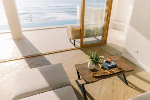 a living room with a table and a view of the ocean at Palms La Union Beachfront Suites in San Juan